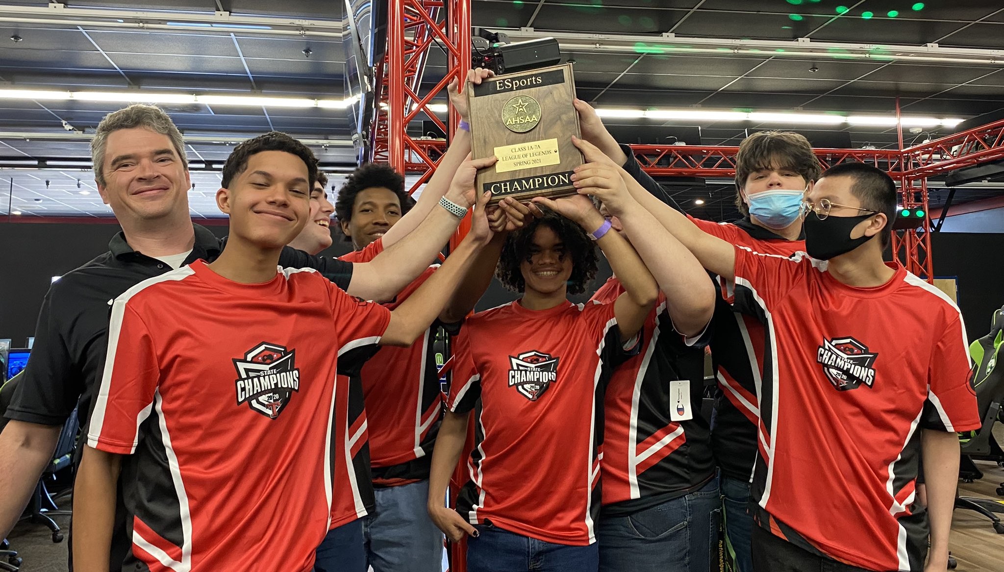 Spencer Stone with students holding an esports championship plaque